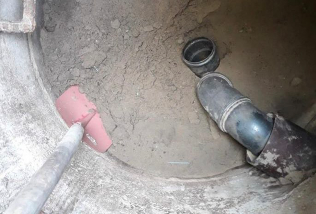 Nahaufnahme eines Kanalschachts mit Rohren und Werkzeug, Kanalreinigung in Hannover